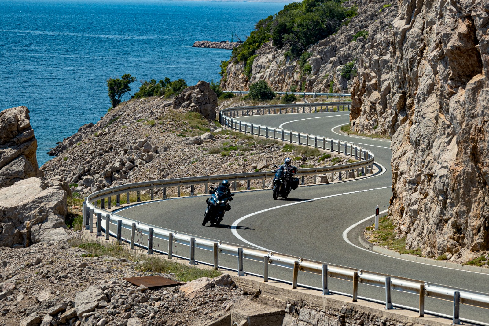 Motorcyclists riding a sweeping Adriatic coastal road